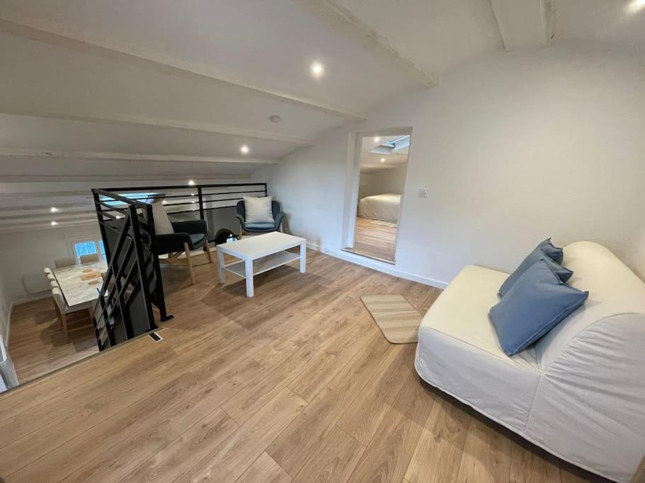 a living room with a couch and a dining room at Duplex sous les toits in Riez