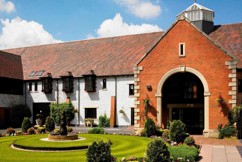 a large brick building with a large archway at Forest of Arden Hotel and Country Club in Bickenhill