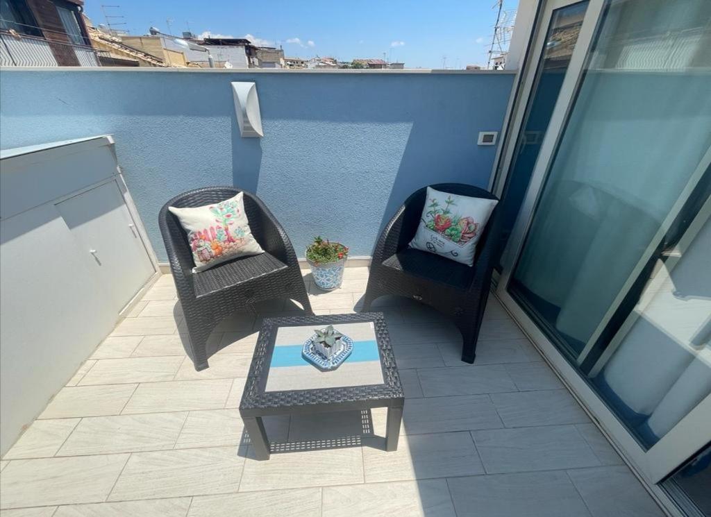 2 chaises et une table basse sur un balcon dans l'établissement Borgata Mazzarelli 2, à Marina di Ragusa