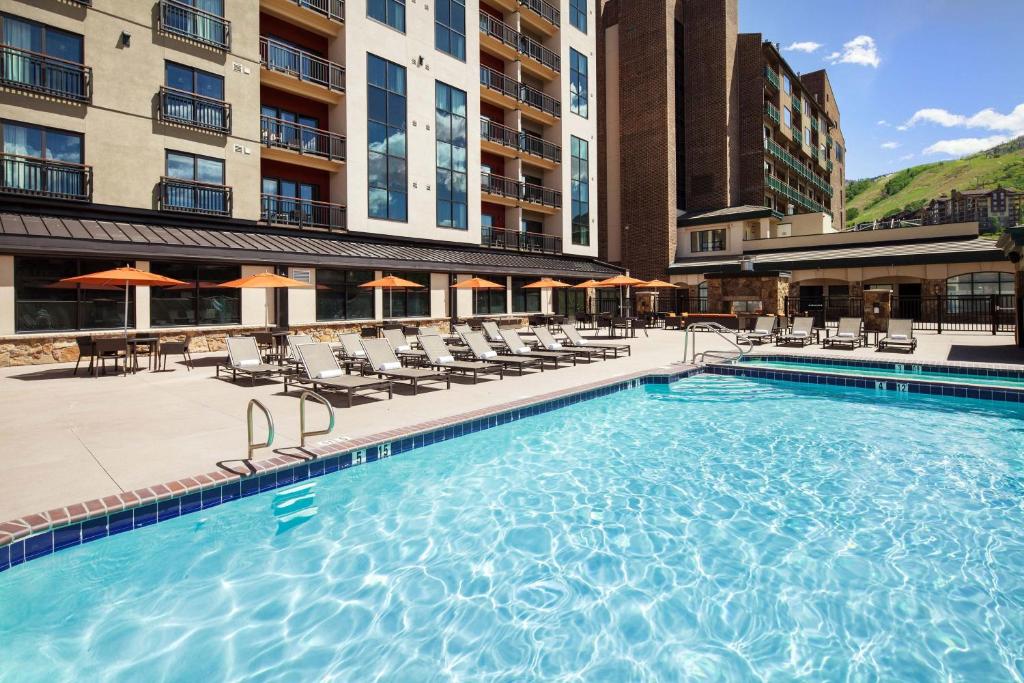 a large swimming pool with chairs and a hotel at Sheraton Steamboat Resort Villas in Steamboat Springs