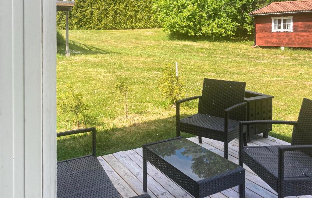 a porch with two chairs and a glass table at Cozy Home In Blankaholm With Wifi in Blankaholm