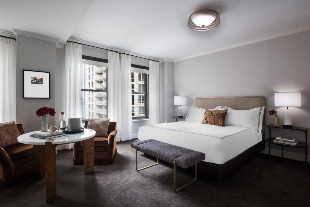 a bedroom with a bed and a table and a chair at The Talbott Hotel in Chicago