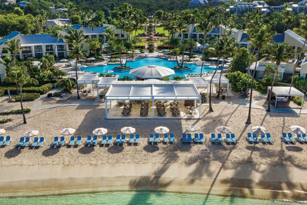 an aerial view of a resort pool with chairs and umbrellas at The Westin St. John Resort Villas in Saint John