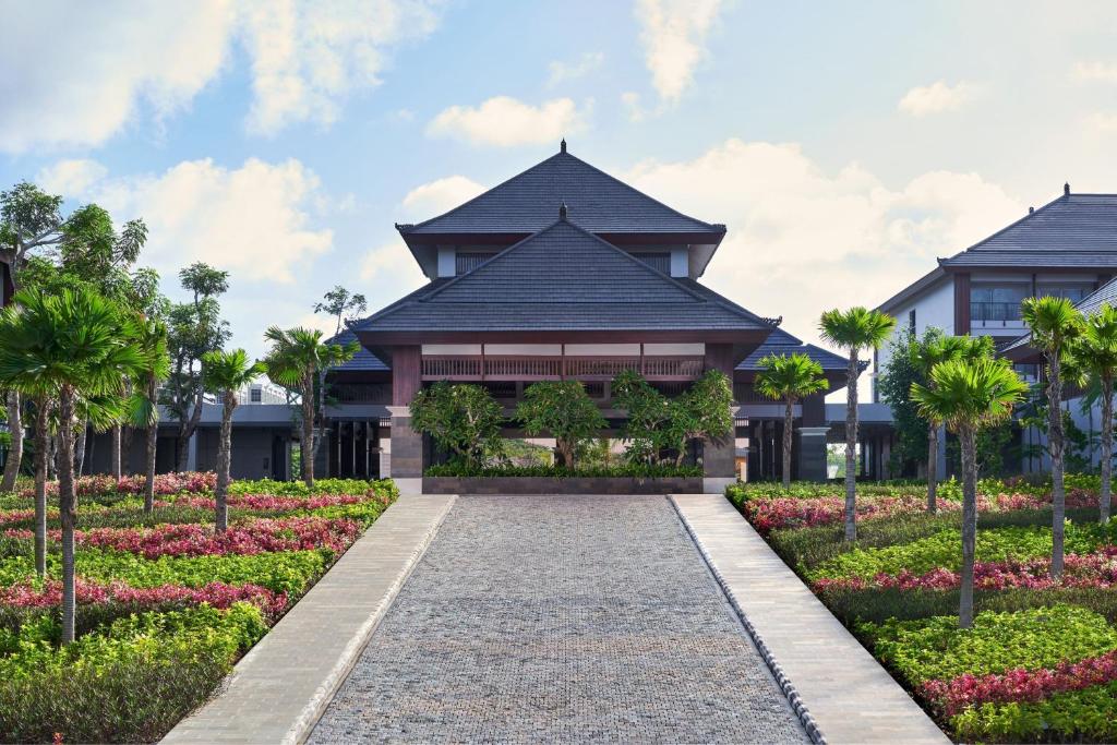 a villa with a garden in front of a building at Marriott's Bali Nusa Dua Terrace in Nusa Dua