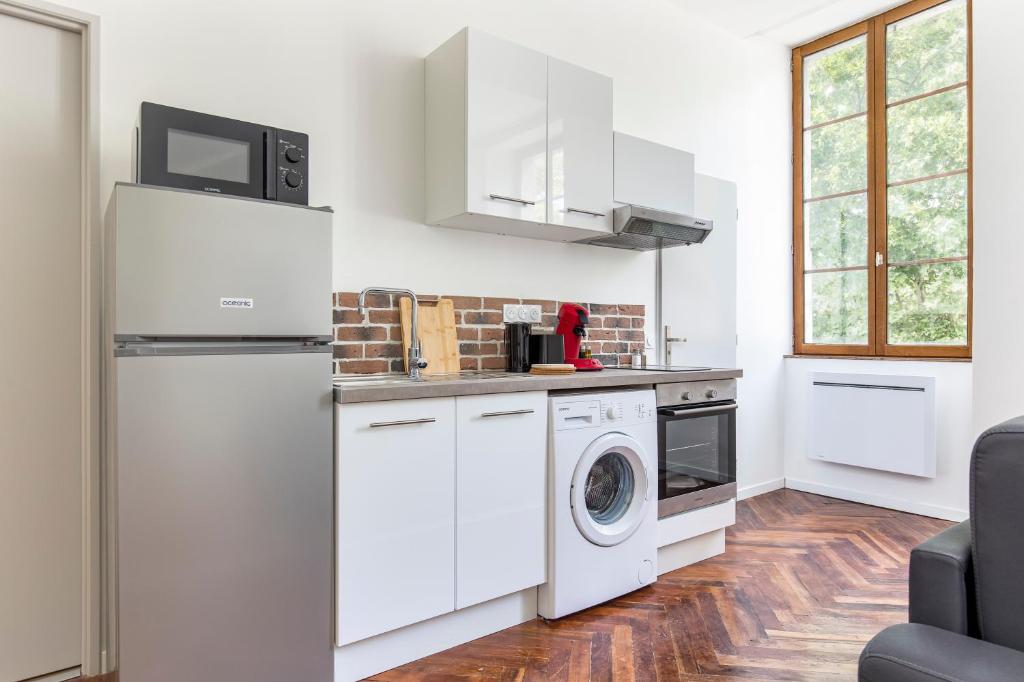 a kitchen with a refrigerator and a washer and dryer at Gambetta 304 CahorsCityStay in Cahors