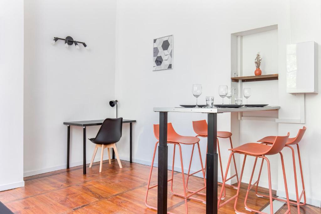 a kitchen with a table with orange chairs at Gambetta 304 CahorsCityStay in Cahors