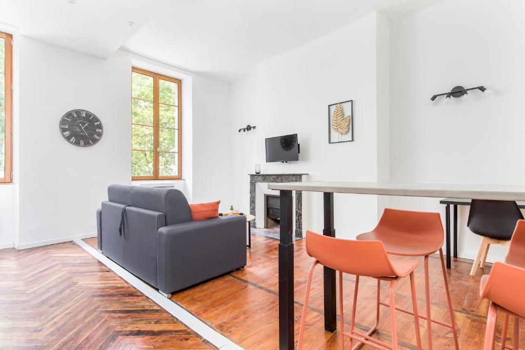 a living room with a table and chairs at Gambetta 304 CahorsCityStay in Cahors