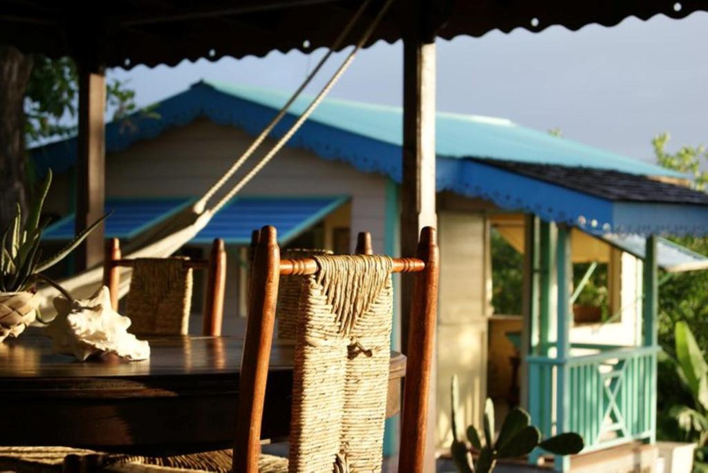 einen Tisch und Stühle unter einem Regenschirm vor einem Haus in der Unterkunft Italian Guesthouse in Gros Islet