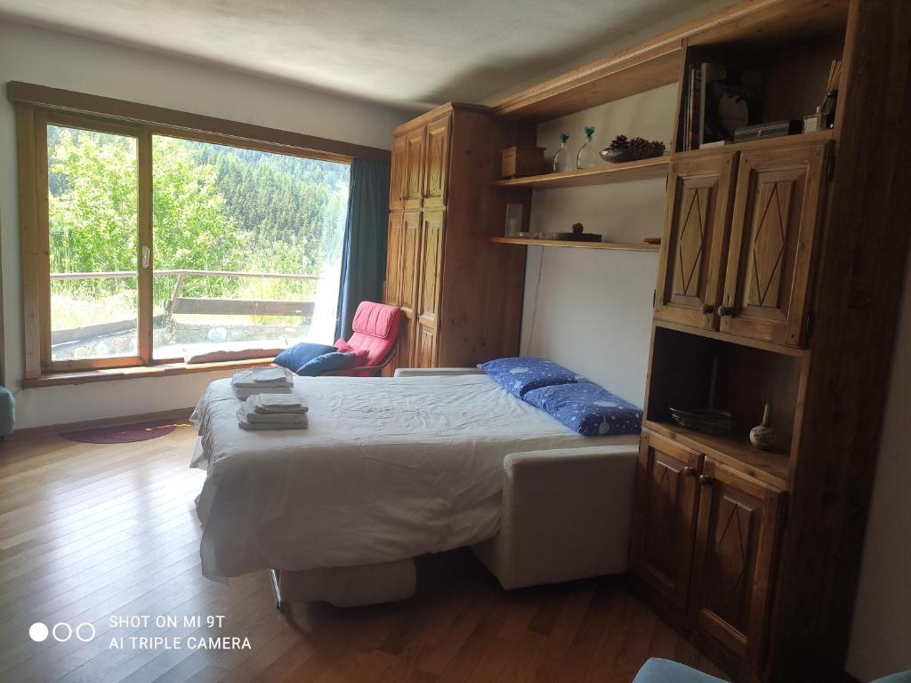 ein Schlafzimmer mit einem Bett und einem großen Fenster in der Unterkunft Appartamento Pila in Pila