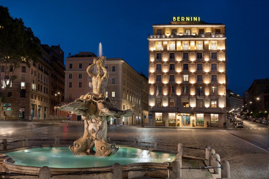uma fonte no meio de uma rua com um edifício em Sina Bernini Bristol, Autograph Collection em Roma