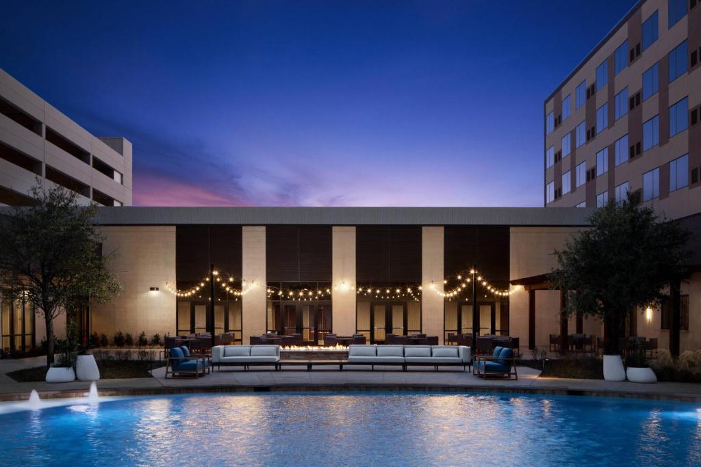 a hotel with a pool in front of a building at Marriott Dallas Allen Hotel & Convention Center in Allen