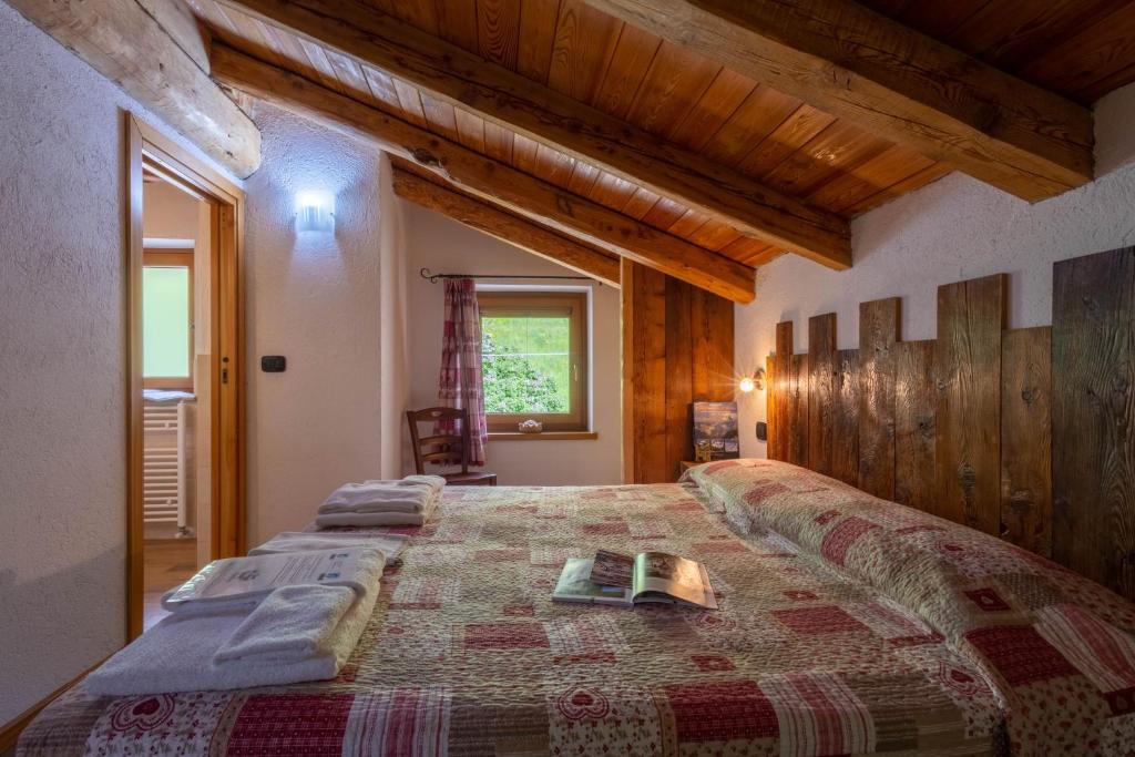 sypialnia z łóżkiem i książką na nim w obiekcie Le Vieux Noyer - Appartamenti al Verde villaggio di Rumiod w mieście Saint-Pierre