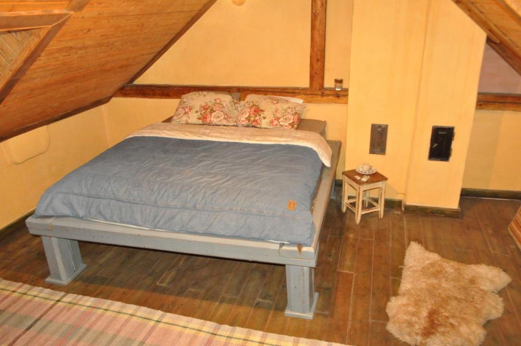 um pequeno quarto com uma cama no sótão em Vintage cozy village house em Spišská Nová Ves