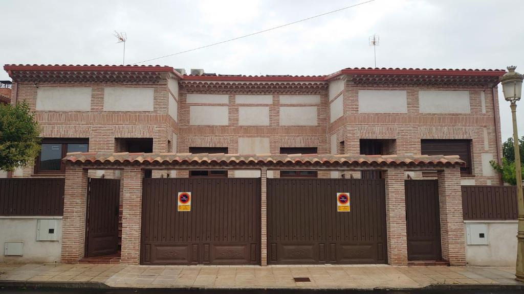 a brick building with two sets of garage doors at OTERO&ELMA in Alovera
