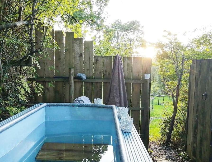 a swimming pool in front of a wooden fence at Penn Bergeyn Shepherd's Huts in Exeter