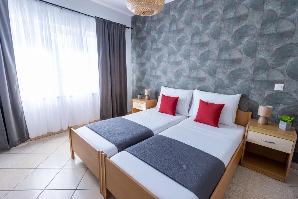 a bedroom with two beds and a stone wall at LUXURY ROOMS BURE in Murter