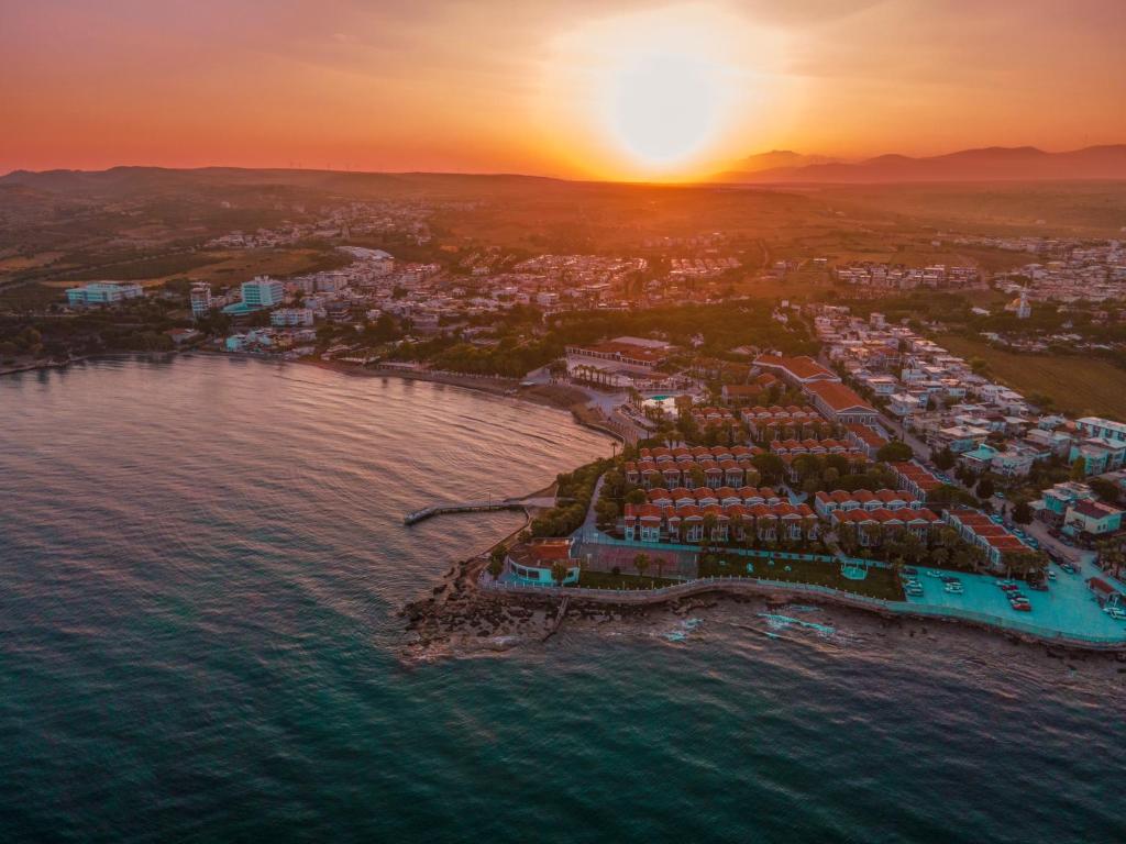 Una vista aérea de una ciudad costera al atardecer. en LUCAS DIDIM RESORT, en Yenihisar