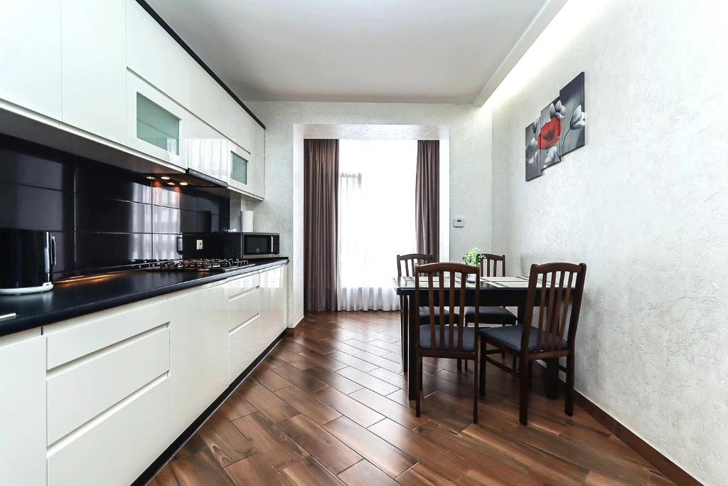 Cozy apartment on Belvedere في ايفانو - فرانكيفسك: مطبخ مع طاولة وكراسي في غرفة