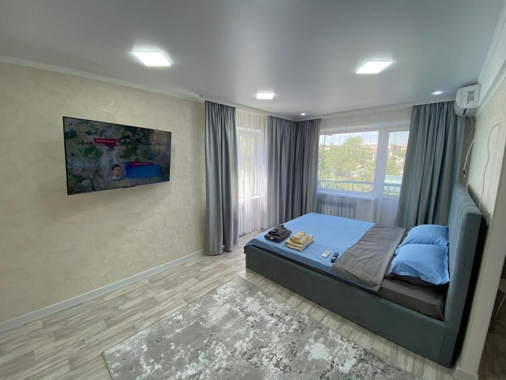 ein Schlafzimmer mit einem Bett und einem großen Fenster in der Unterkunft Апартаменты Балхаш (Набережная) in Balqasch