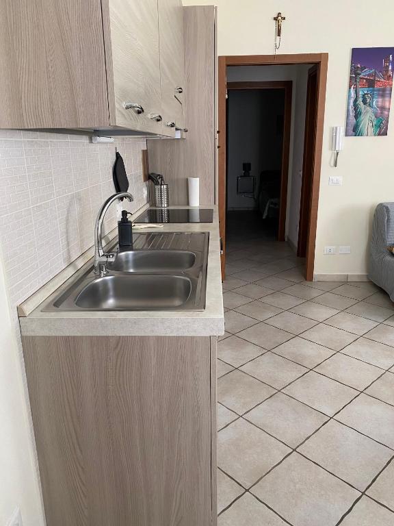 una cucina con lavandino e pavimento piastrellato di Saba's House a Ghizzano