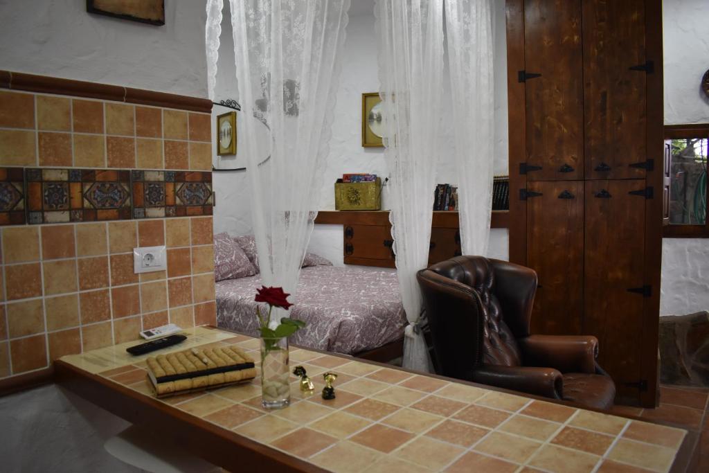 a room with a table with a chair and a bed at ROMANTICA in San Bartolomé