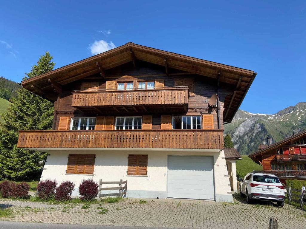 a large wooden house with a gambrel roof at Chalet Happy in Adelboden