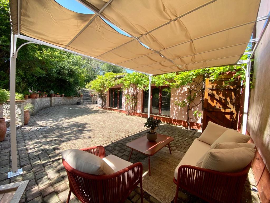 een patio met een bank, stoelen en een tafel bij Casal Camillo in Case Selva Grande