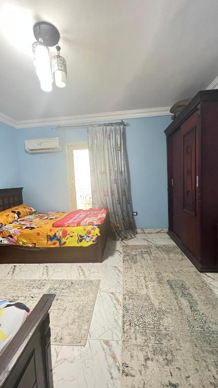 een slaapkamer met een bed en een raam bij شقه للايجار بمدينه نصر in Caïro