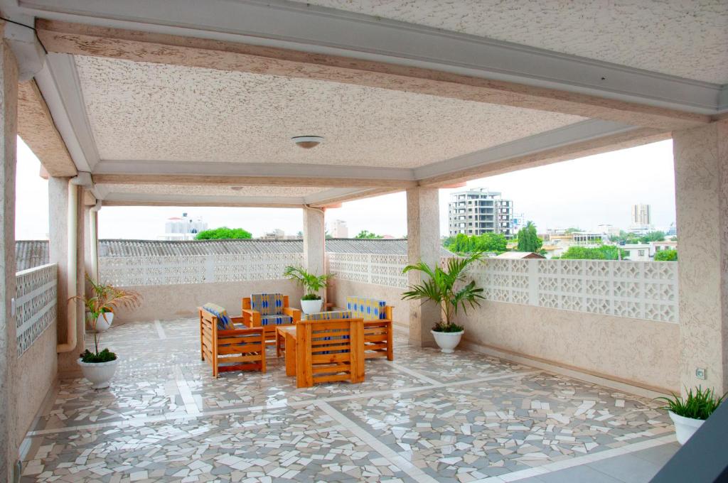 eine Terrasse mit Stühlen und Tischen auf dem Balkon in der Unterkunft Résidences 509 in Lomé