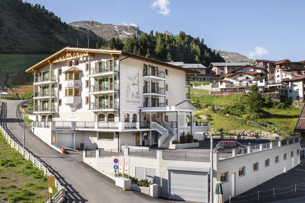 a large white building on the side of a road at Hotel Grünerhof in Obergurgl