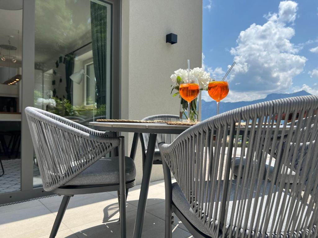 una mesa con dos sillas y un jarrón de flores en EXCLUSIVES APARTMENT - Auszeit Mondsee en Mondsee