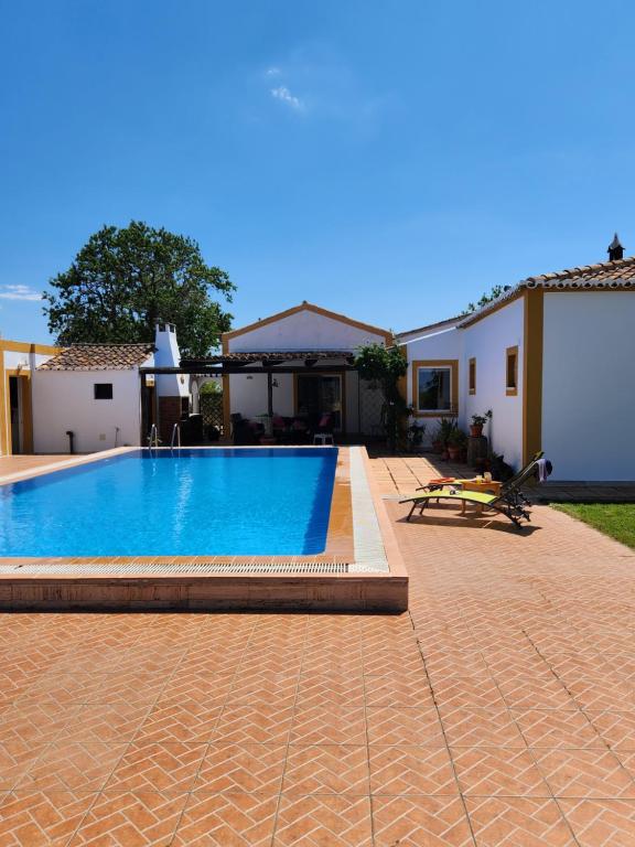 a swimming pool in front of a house at Quinta Das Amendoas in Carvoeiro