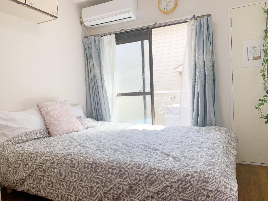 Schlafzimmer mit einem Bett und einem Fenster in der Unterkunft Shinjuku Area/Nishi-Shinjuku Gochome subway 6 minutes walk/西新宿五丁目车站步行6分钟 211 in Tokio