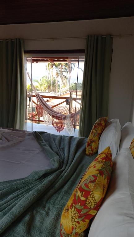a bedroom with a bed with a view of a patio at POUSADA ACONCHEGO CHAPADA in Alto Paraíso de Goiás