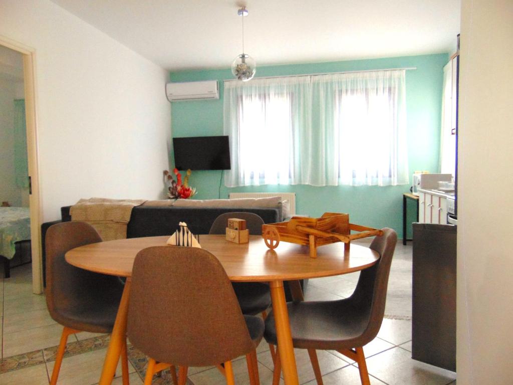 a dining room table with chairs and a living room at Marilena Apartment, Keremies in Keramiaí