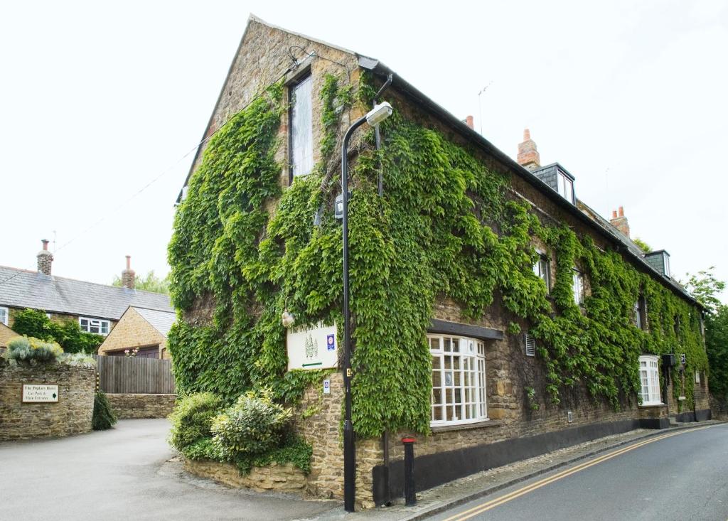 an ivy covered building on the side of a street at The Poplars Hotel in Moulton