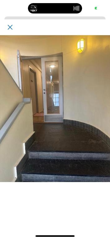 una escalera en un edificio con una persona en la puerta en Fancy Homes - Modern 70m2 apartment en Jessheim