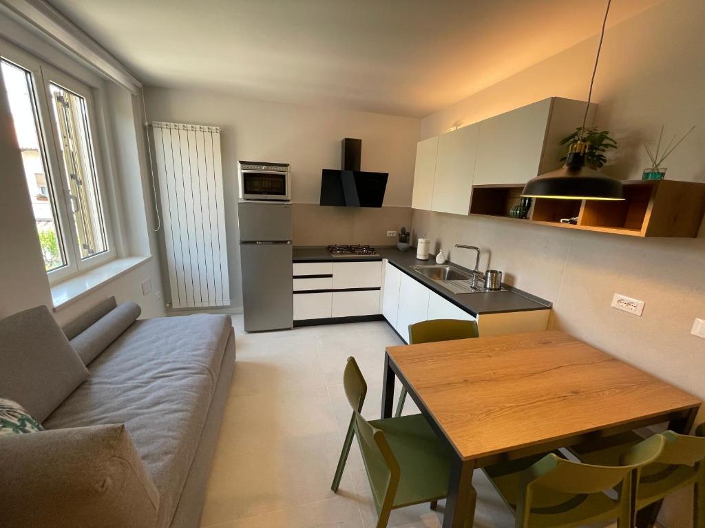 a kitchen and living room with a couch and a table at San Pietro D'orio Verde in Grado