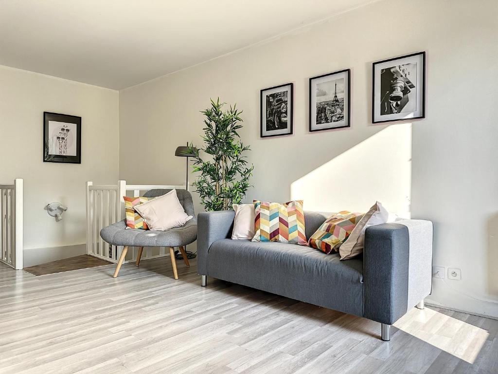 un salon avec un canapé et une chaise dans l'établissement Charmant appartement avec terrasse parking, à Ispagnac