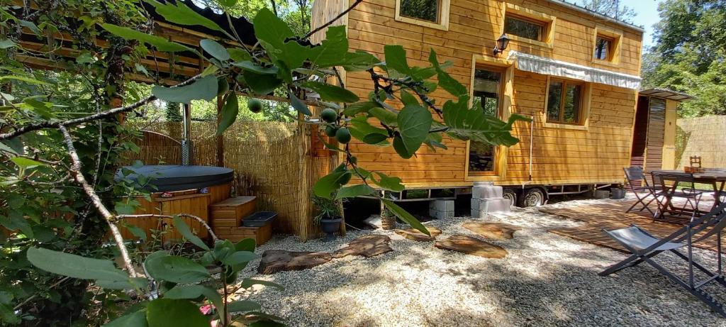 Cabaña de madera con parrilla y mesa en Mini maison tiny house et son bain nordique, en Figeac