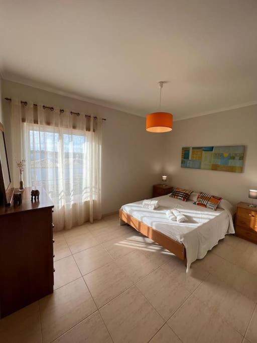 ein Schlafzimmer mit einem großen Bett und einem großen Fenster in der Unterkunft Apartamento Falésia c/ Piscina in Albufeira