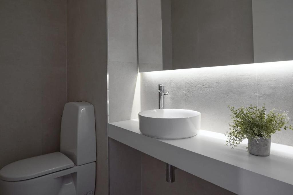 a white bathroom with a sink and a toilet at Stay In Apartments - D. Hugo 23 in Porto