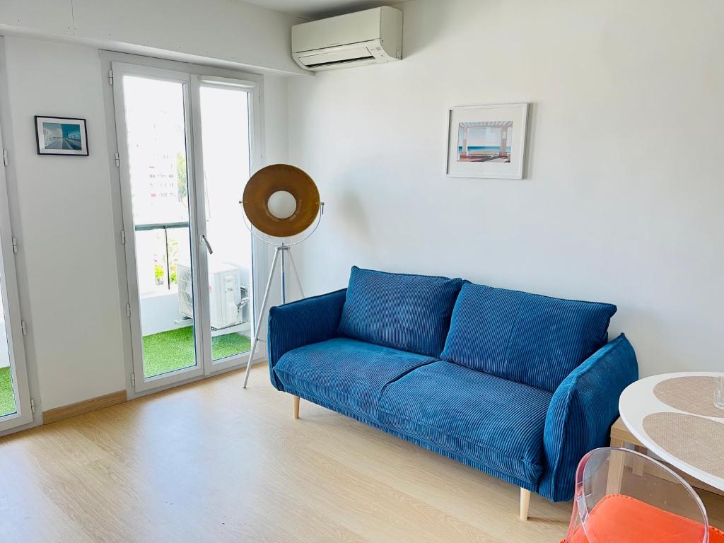 a blue couch in a living room with a table at Nice comfortable sea view in Nice