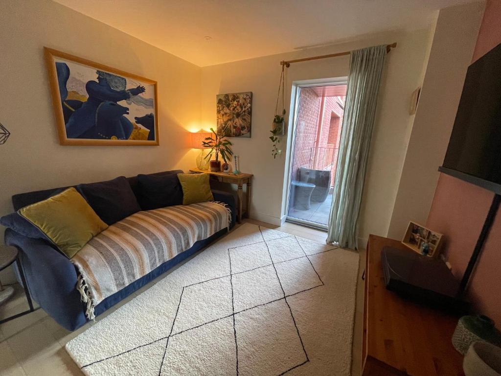 a living room with a couch and a window at Nunhead Green Flat in London