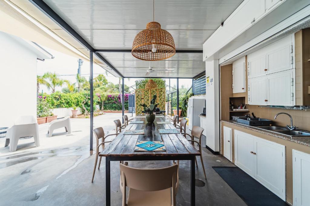 een keuken en eetkamer met een lange tafel en stoelen bij Airport sicily home palermo in Carini