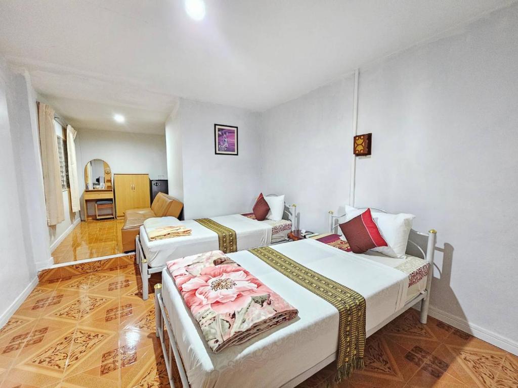 um quarto de hotel com duas camas e um sofá em P.California Inter Hostel em Nang Rong