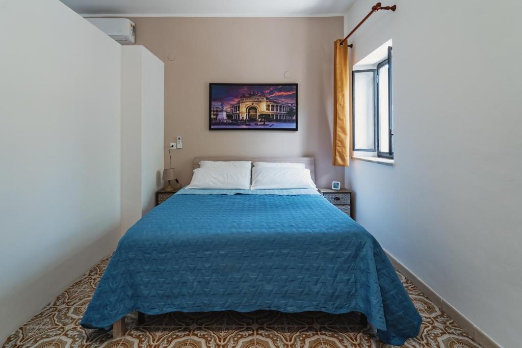 a bedroom with a bed with a blue blanket at Airport sicily home palermo in Carini