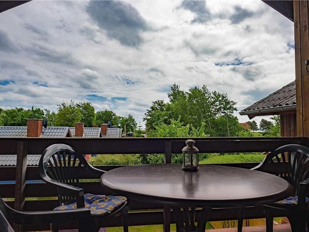 uma mesa e cadeiras sentadas num alpendre com vista em Ferienwohnung "Polly" em Glücksburg