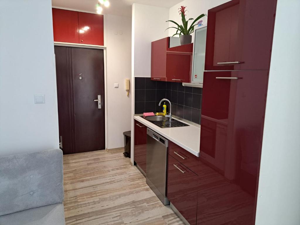 - une cuisine avec des placards rouges et un évier dans l'établissement Maris, à Split