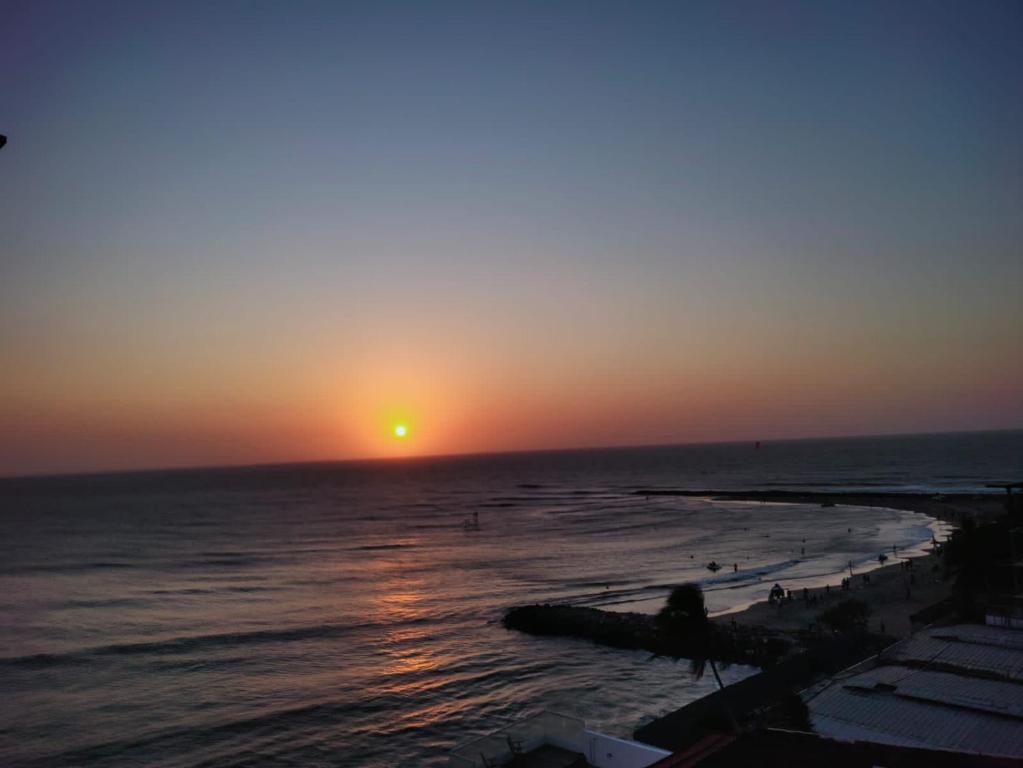 a sunset on the beach with people on the shore at FRAGATA STYLE 2 in Cartagena de Indias